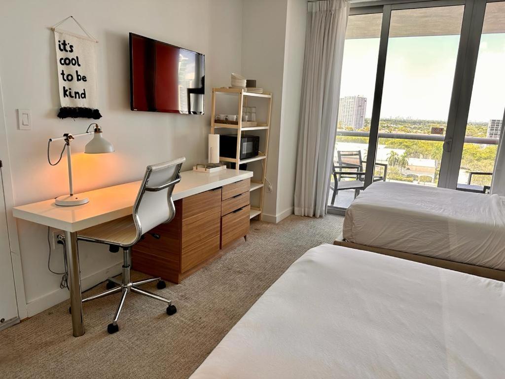 a bedroom with a desk and a bed and a bed and a desk and chair at 2 Full Beds Ocean Air, Relaxing Studio Stay in Hallandale Beach