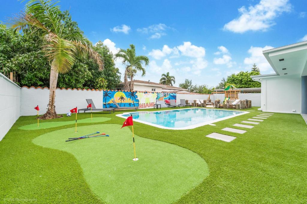a golf course in the yard of a house at Modern Chic Retreat Pool Full amenities backyard L10 in Miami