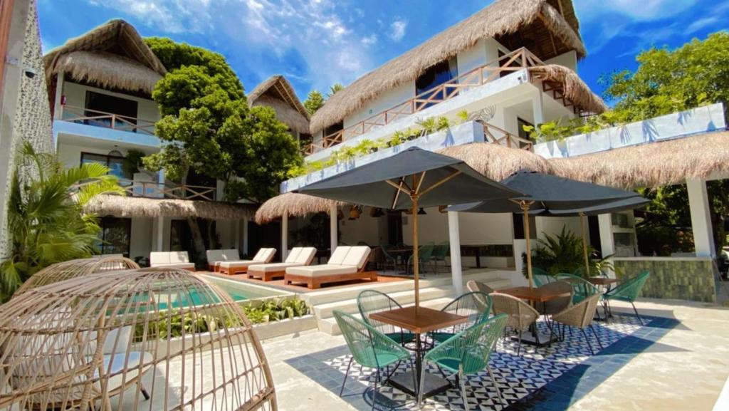 an image of a villa with chairs and umbrellas at Hotel Sun Ha Bacalar in Bacalar