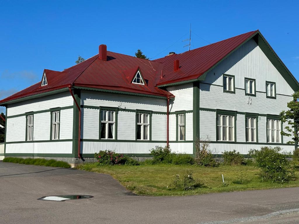uma grande casa branca com um telhado vermelho em Majoitus Wanhapankki, huoneisto B2 em Kalajoki