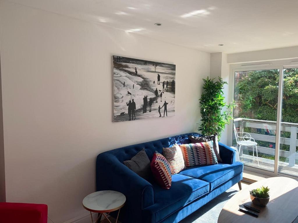a blue couch in a living room with a window at Scarborough - Stylish 2 Bedroom Flat on the Spectacular Esplanade in Scarborough