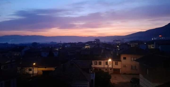 a view of a city at sunset with mountains in the background at Spa Luxury Homes Banya in Banya