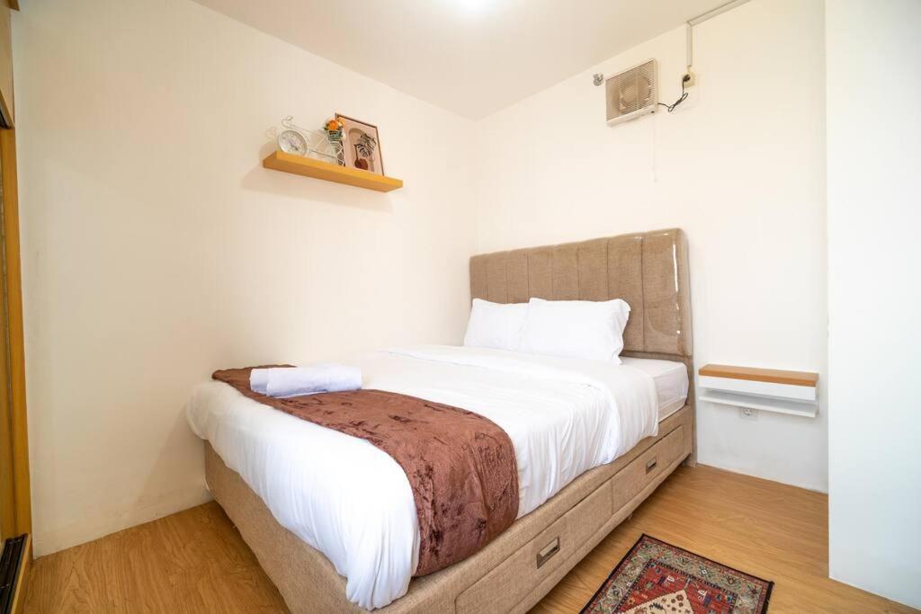 ジャカルタにあるElegance 2BR @ Bassura City East Jakarta /Netflixの白いシーツが敷かれた大きなベッドのある寝室