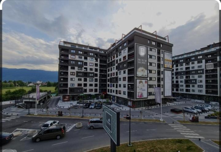 een parkeerplaats met twee grote gebouwen en auto's bij Blue Moon Bulevar in Sarajevo