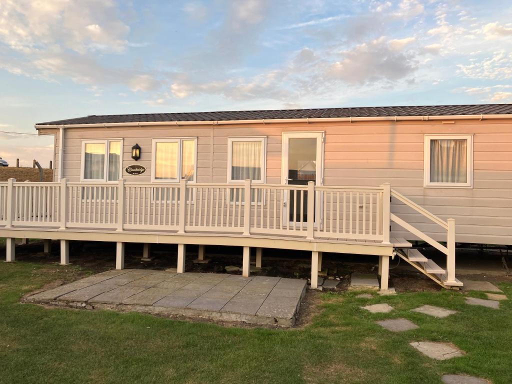 ein Haus mit einer großen Terrasse und einem Haus in der Unterkunft Staycay Luxury Caravan in Seasalter