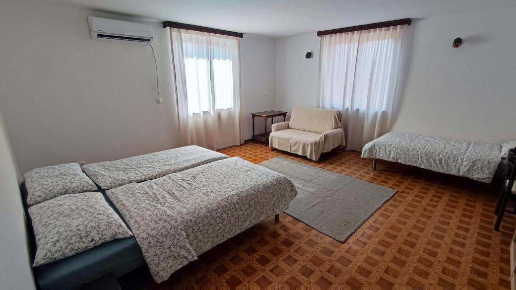 a bedroom with a bed and a chair in it at Altana Rooms in Koper