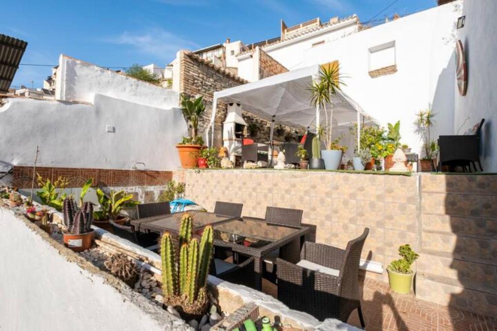 a patio with a table and chairs and cactus at Brily home in Vélez-Málaga