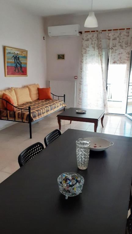 a living room with a table and a couch at Lampros apartments in Loutra Edipsou