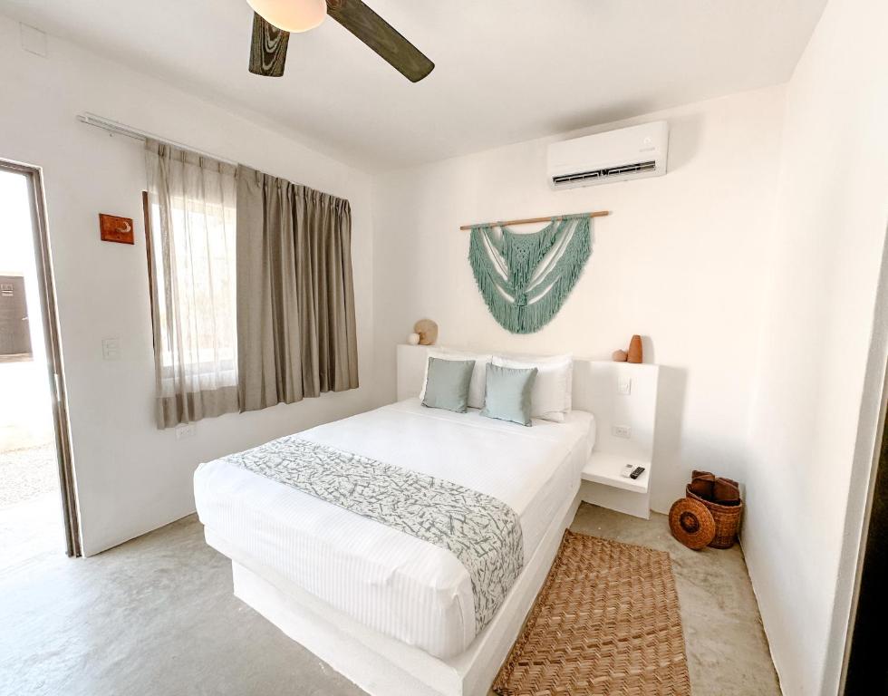 Un dormitorio blanco con una cama blanca y una ventana en HAU Holbox, Beach Front, en Isla Holbox