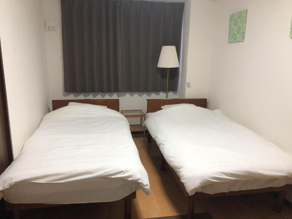 two beds in a room with white sheets at HOTEL LUCKY - Vacation STAY 49954v in Osaka