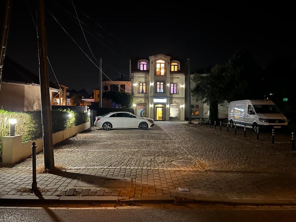 a white car parked in front of a building at night at Salt INN Apartments No 2 - jacuzzi in Wieliczka