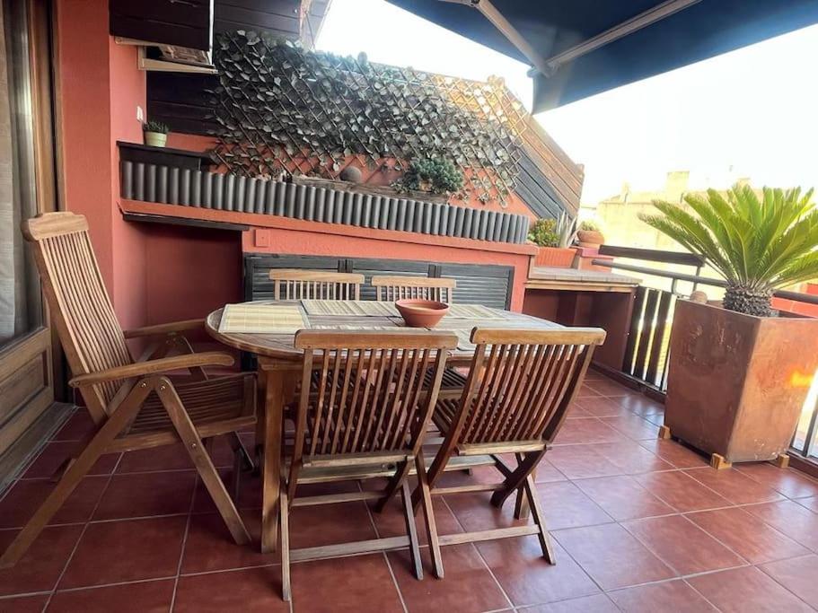 una mesa de madera y sillas en un patio en Ático luminoso céntrico y cómodo en Figueres