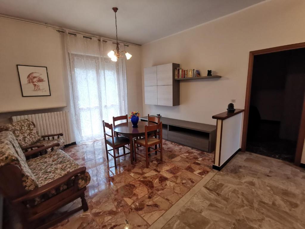 un soggiorno con tavolo, sedie e TV di CasaUmberto a Nizza Monferrato