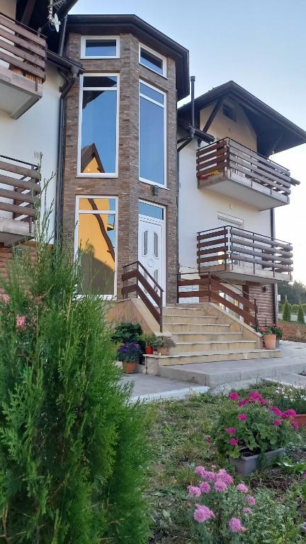 una casa con scale e finestre e alcuni fiori di Apartman Popović - Vila Gorštak a Divčibare