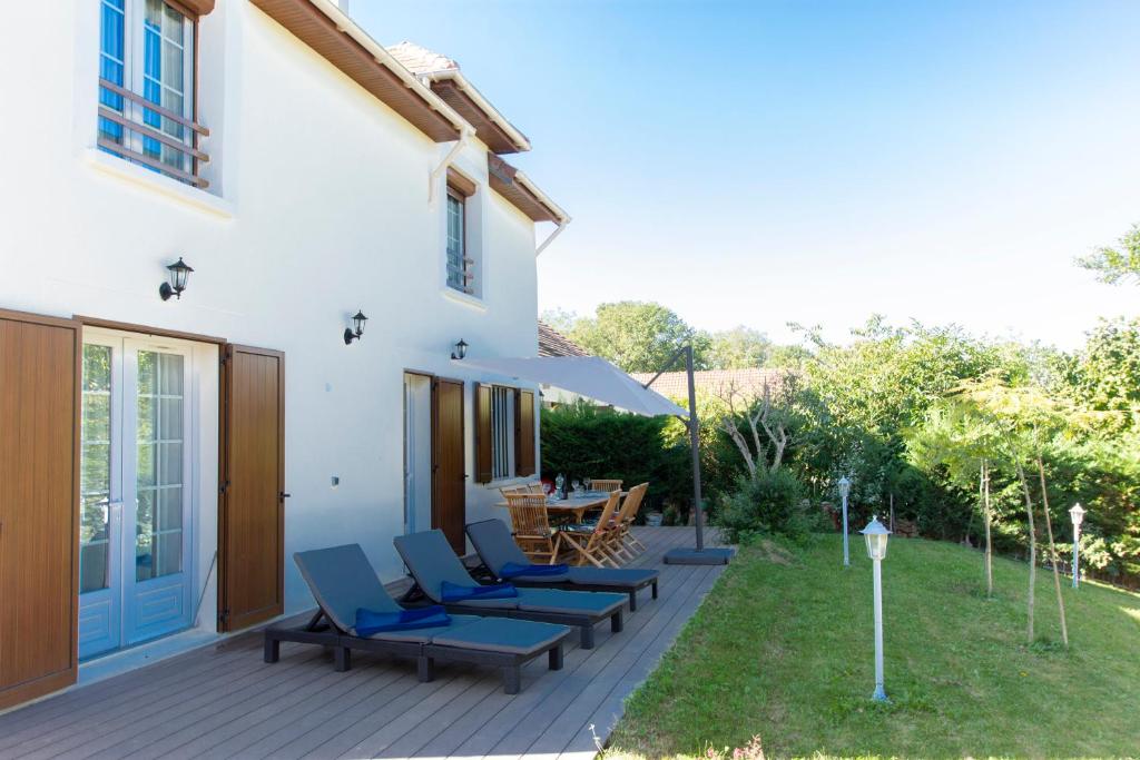 a patio with blue lounge chairs and a table at Chalet Like Upstairs Private Suite in Étiolles