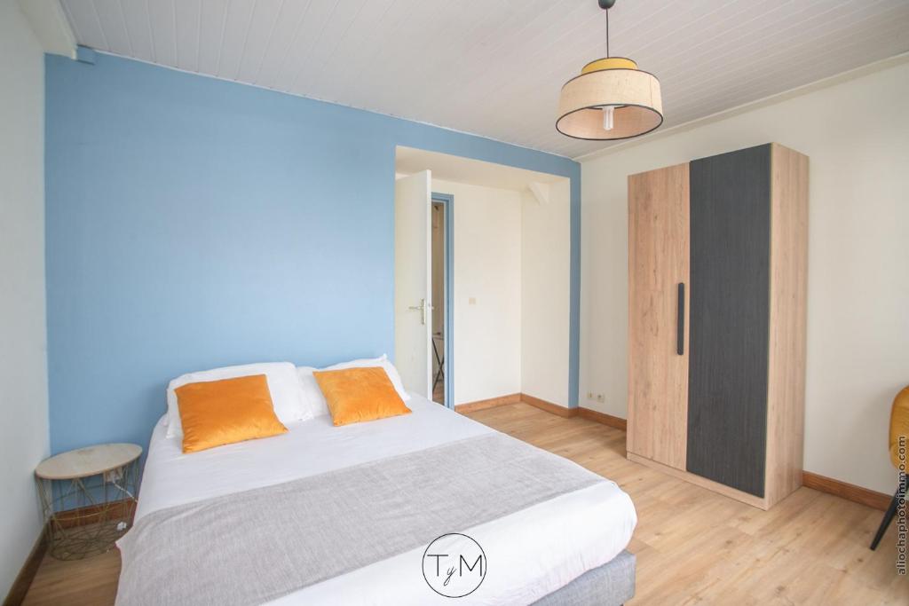 a bedroom with a bed and a blue wall at Foyal City Center in Fort-de-France