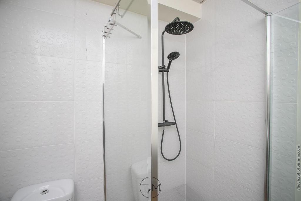 a shower with a glass door in a bathroom at Foyal City Center in Fort-de-France