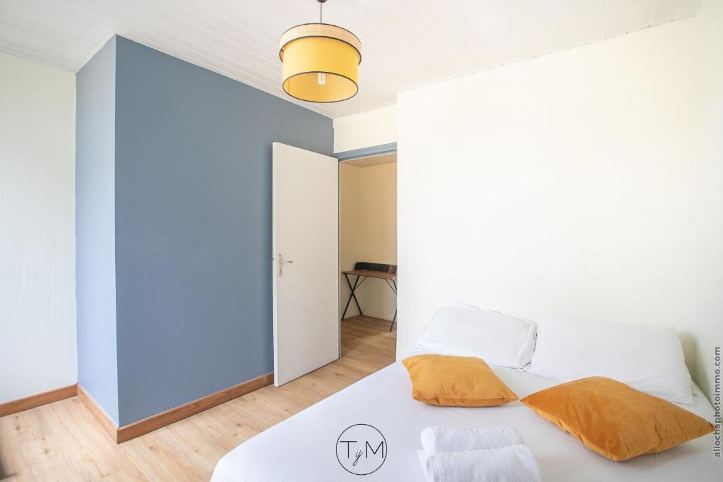 a bedroom with a white bed and a blue wall at Foyal City Center in Fort-de-France