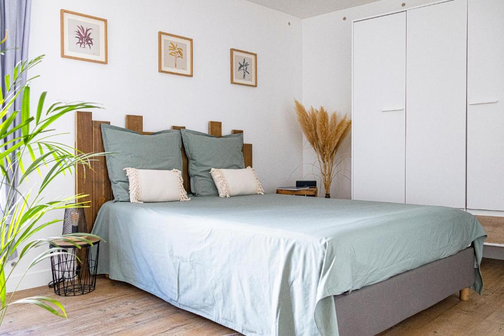 a bedroom with a bed with blue sheets and pillows at Joli nid douillet proche Nîmes in Bouillargues