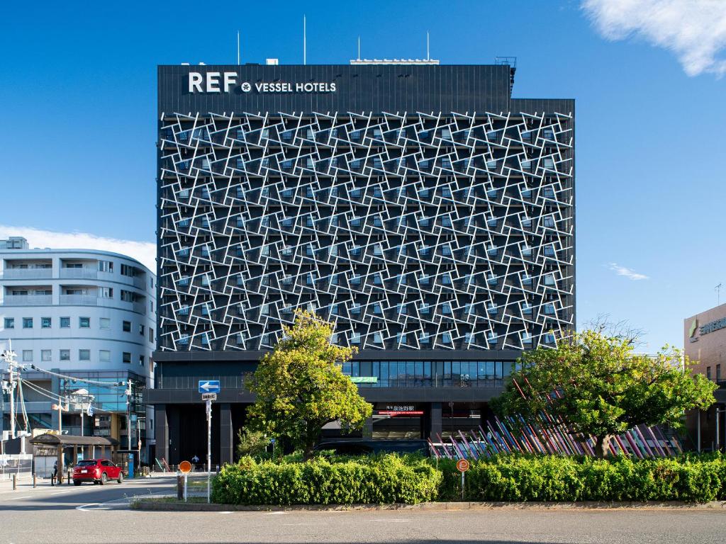 a building with a sign on the side of it at REF Kanku-Izumisano by VESSEL HOTELS in Izumi-Sano