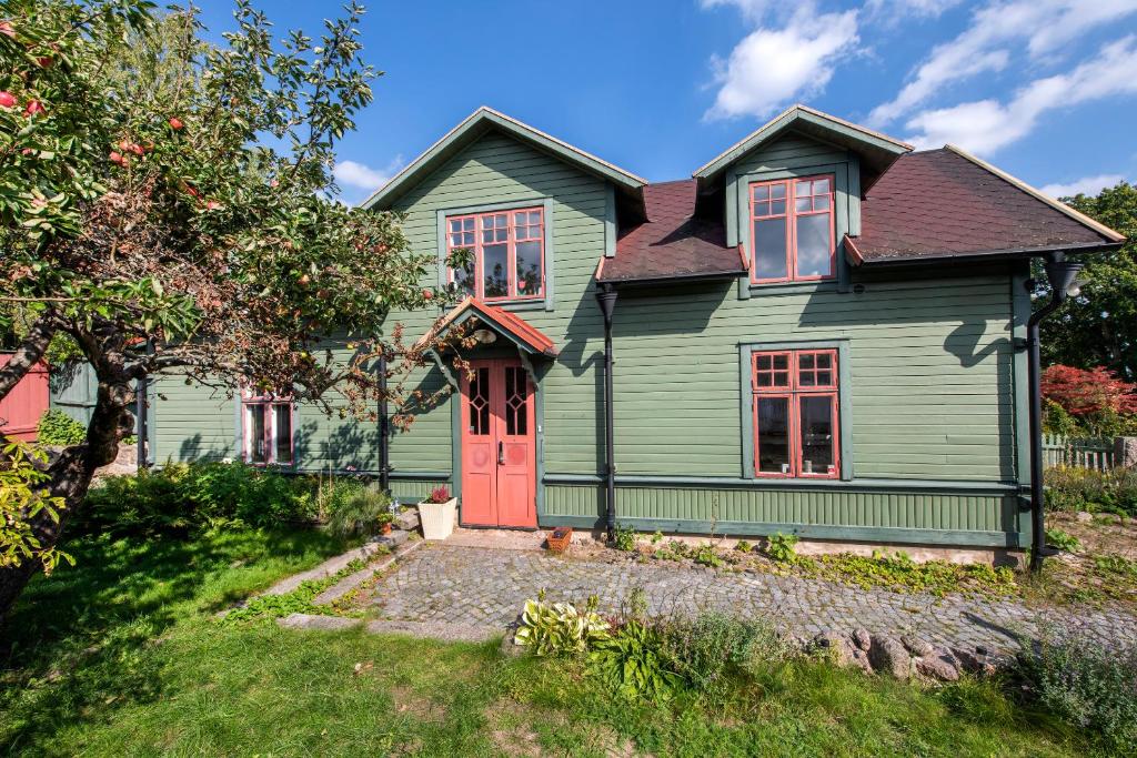 una casa verde con puerta roja en Modern house in Ronneby near lake and sea, en Ronneby