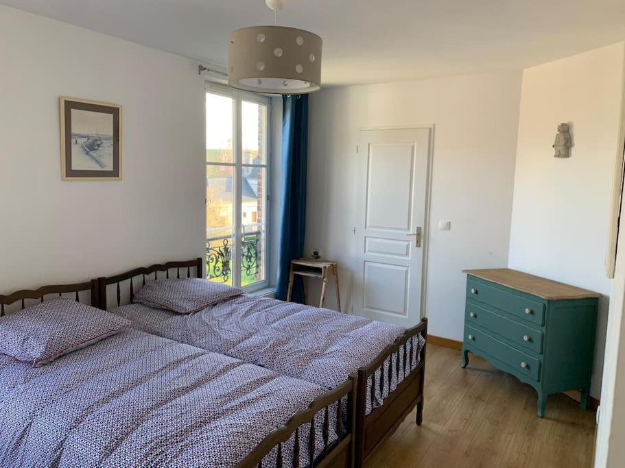 a bedroom with a bed with a blue dresser and a window at La cabine d&#39;Amélie in Veules-les-Roses