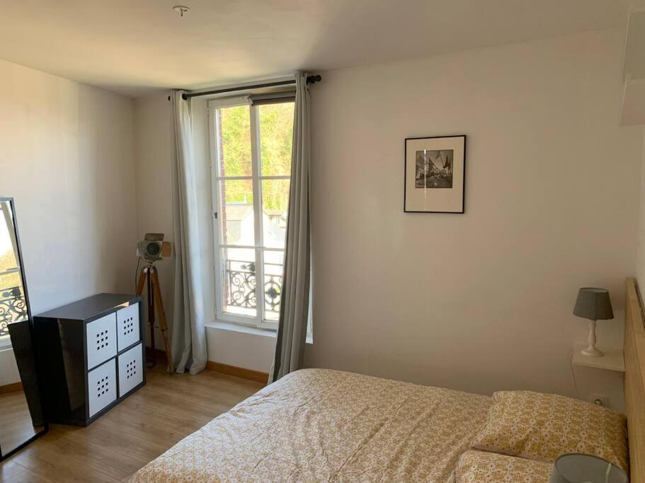 a bedroom with a bed and a window at La cabine d&#39;Amélie in Veules-les-Roses
