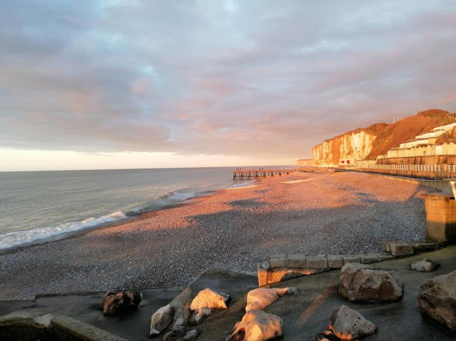 a view of a beach with rocks and a pier at La cabine d&#39;Amélie in Veules-les-Roses