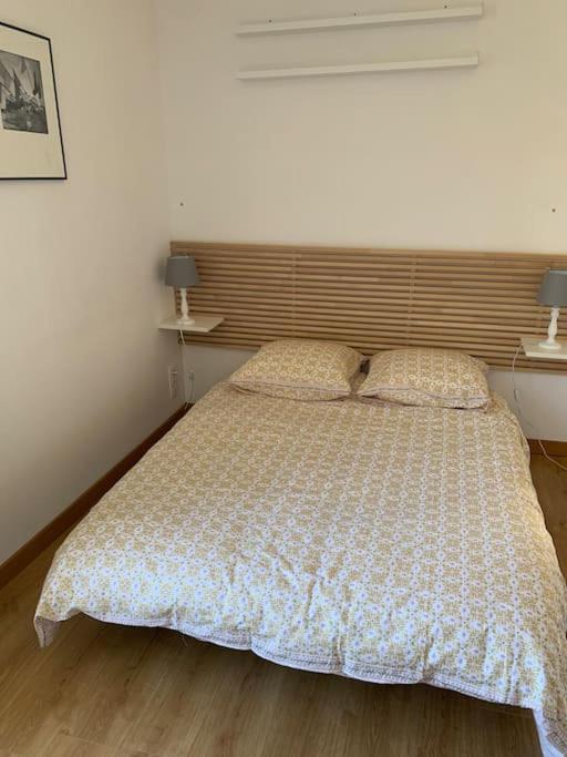 a bedroom with a large bed with two pillows at La cabine d&#39;Amélie in Veules-les-Roses