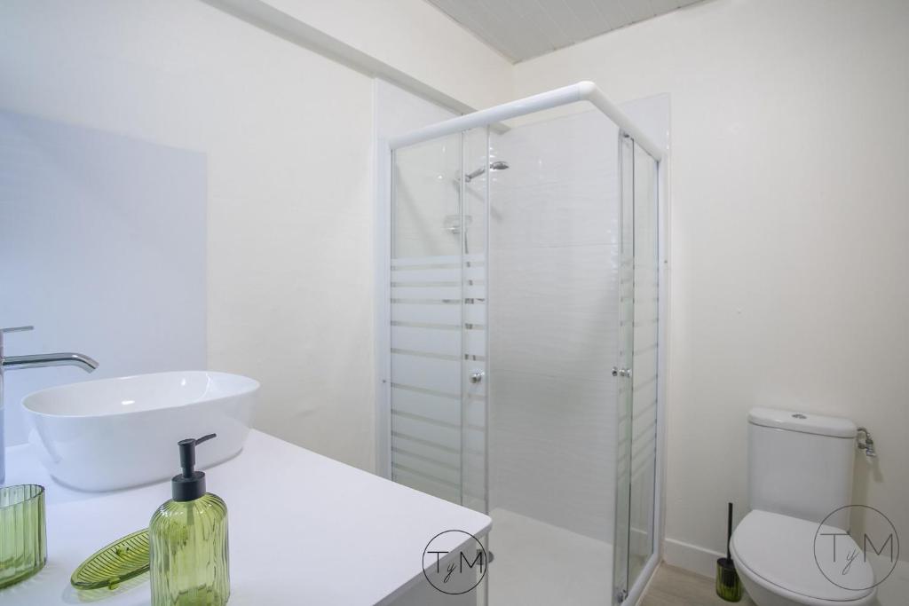 a white bathroom with a sink and a shower at Foyal City Center in Fort-de-France