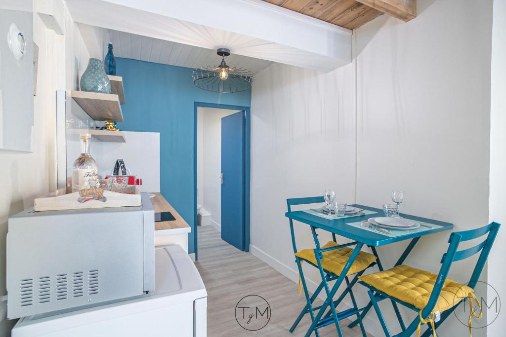 a small kitchen with a blue table and chairs at Foyal City Center in Fort-de-France