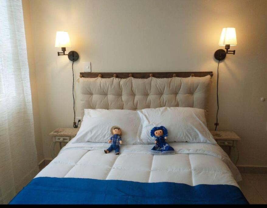 dos muñecas sentadas encima de una cama en Casa Lelé -Linda y acogedora casa de campo para 6 pax en magnífica ubicación, en Tequisquiapan