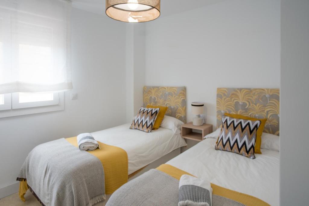 a bedroom with two beds and a chandelier at Luxury Apartment Free Parking in Seville