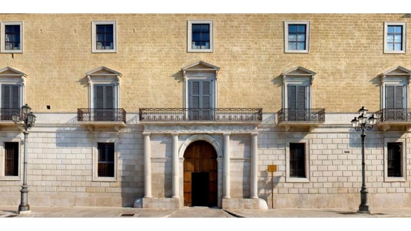 un grande edificio in mattoni con porta e balcone di Maré Resort a Trani