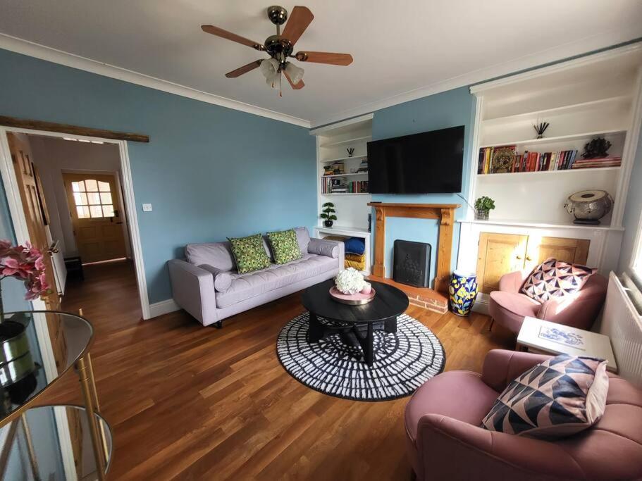 a living room with two couches and a table at Number One Bridgefoot Cottage in West Stockwith