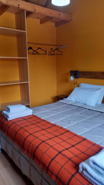 a bedroom with a large bed with a red blanket at kukachalten in El Chalten