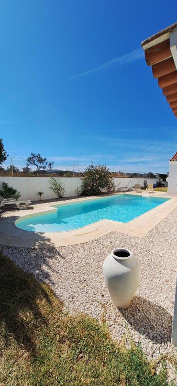 a large white vase sitting next to a swimming pool at Portela Guesthouse in Cercal