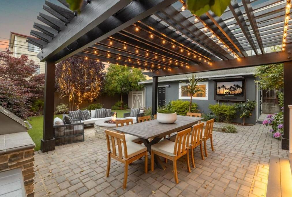 a patio with a table and chairs under a pergola at Walkable Luxury Designer Home in Burlingame