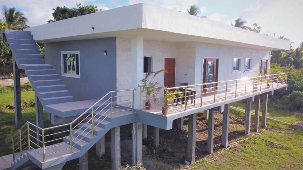 ein Haus auf Stelzen mit einer Treppe, die dorthin führt in der Unterkunft Serenity Seaview Suite in Anse La Raye