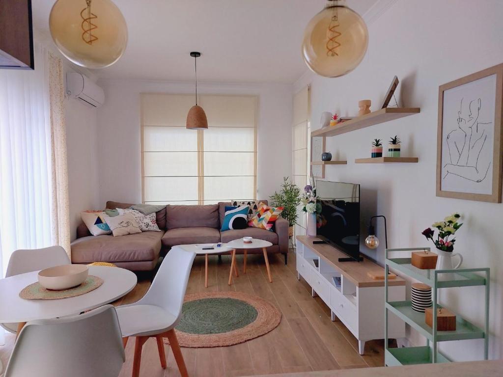 uma sala de estar com um sofá e uma mesa em Caruso apartment em Tivat