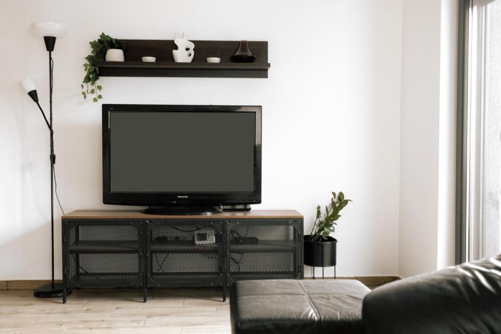 ein Wohnzimmer mit einem Flachbild-TV auf einem Stand in der Unterkunft Backspace Apartments in Vršac