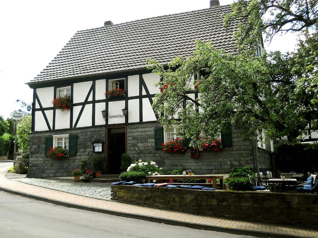 ein schwarzweißes Gebäude mit einem Tisch davor in der Unterkunft Am Alten Fronhof in Bergisch Gladbach