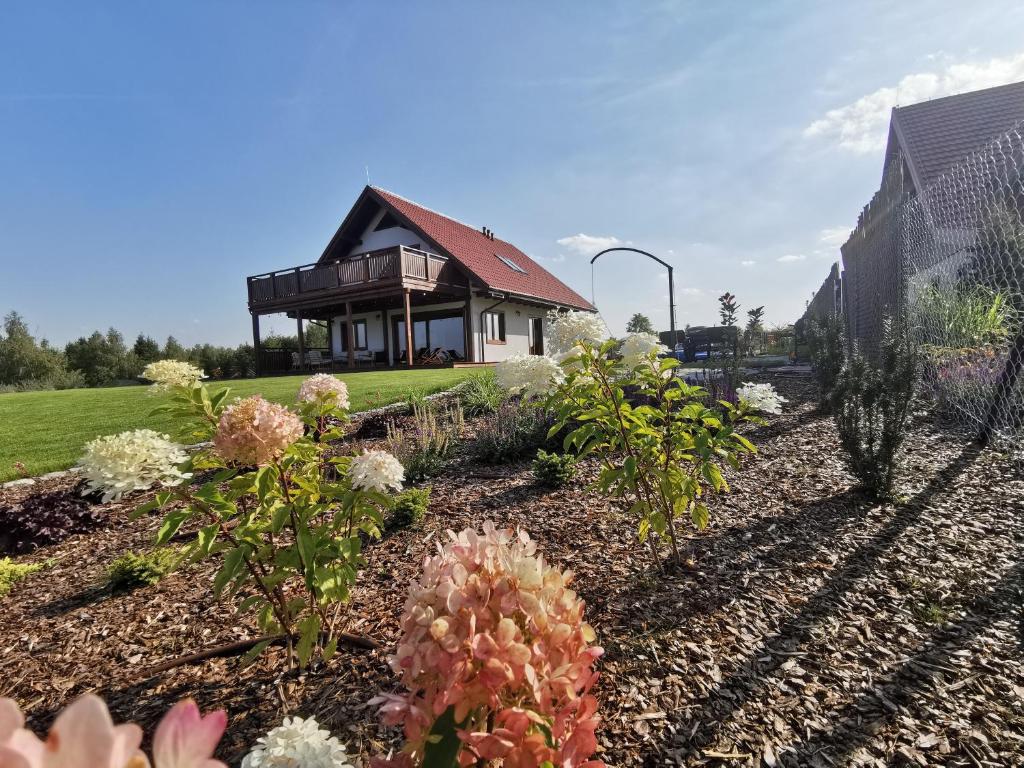 einen Garten mit Blumen vor einem Haus in der Unterkunft Mazurski Horyzont in Leleszki