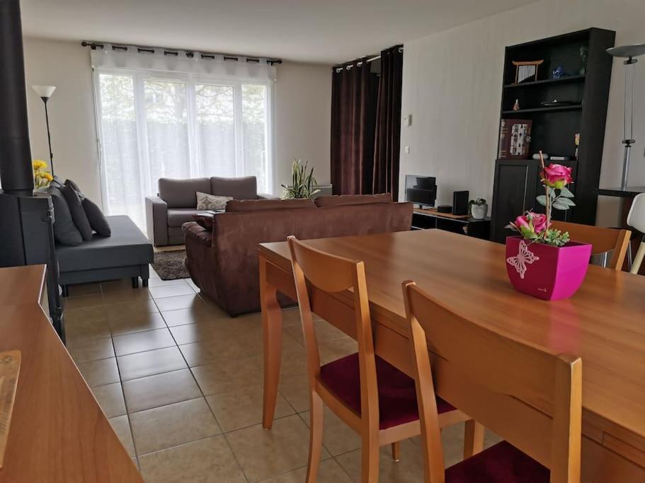 a living room with a wooden table and a couch at Belle maison spacieuse proche Genève et CERN in Saint-Genis-Pouilly