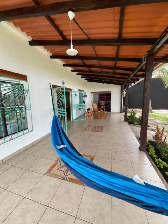 een blauwe hangmat op de patio van een huis bij oasis natural en un paraiso tropical in El Espino