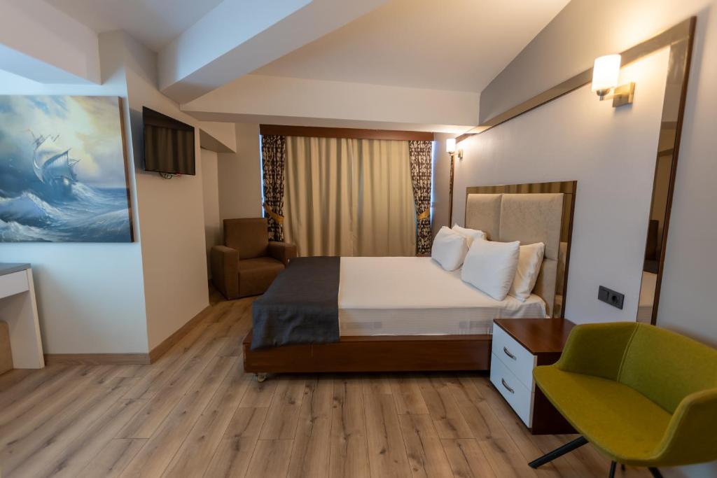 een hotelkamer met een bed en een stoel bij Asia Business Suites in Istanbul