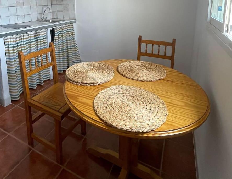 ein Holztisch mit drei Strohhüten darüber in der Unterkunft Casa Veronica 5 , 1 Dormitorio in Arona