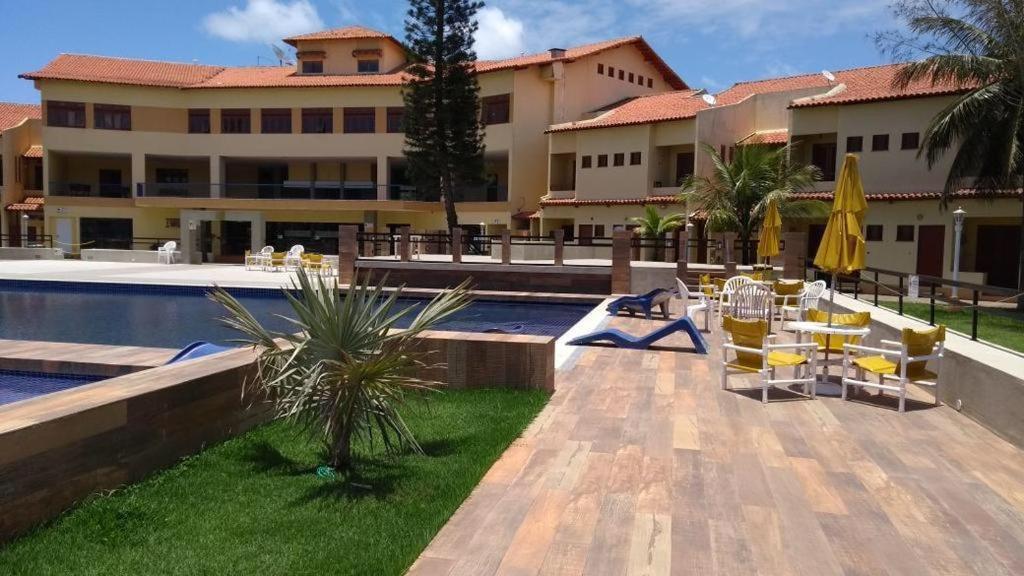 a resort with a swimming pool and a building at Apart-hotel Marinas do Canal in Cabo Frio