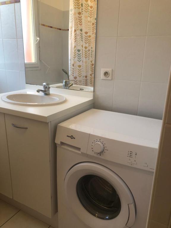 une salle de bains avec lave-linge et lavabo dans l'établissement Superbe T2 à Balaruc les Bains, à Balaruc-les-Bains