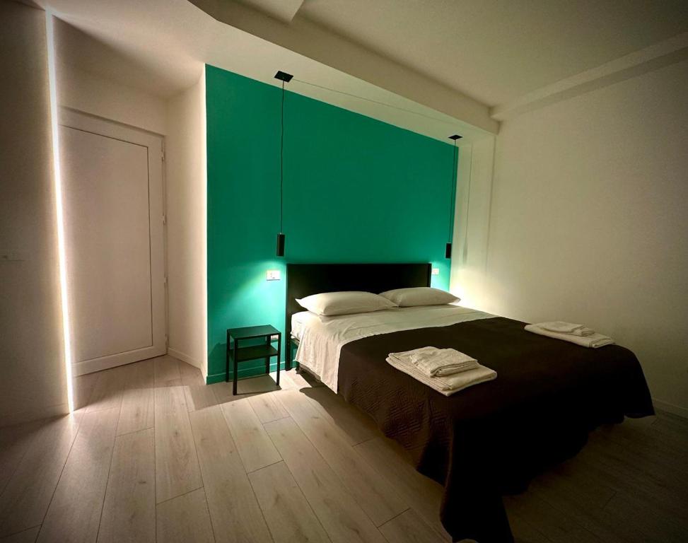 a bedroom with a bed and a green wall at MiPA in Milazzo